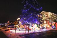 A Street Of Homes At Night With Colourful Christmas Lights Snow On with measurements 1920 X 1080