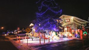 A Street Of Homes At Night With Colourful Christmas Lights Snow On with measurements 1920 X 1080